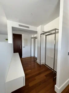Vestidor abierto con armario y perchero metálico dentro de una estancia luminosa de la villa.